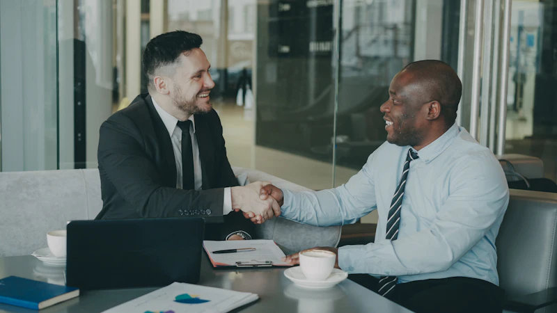 Business partners shaking hands across a desk